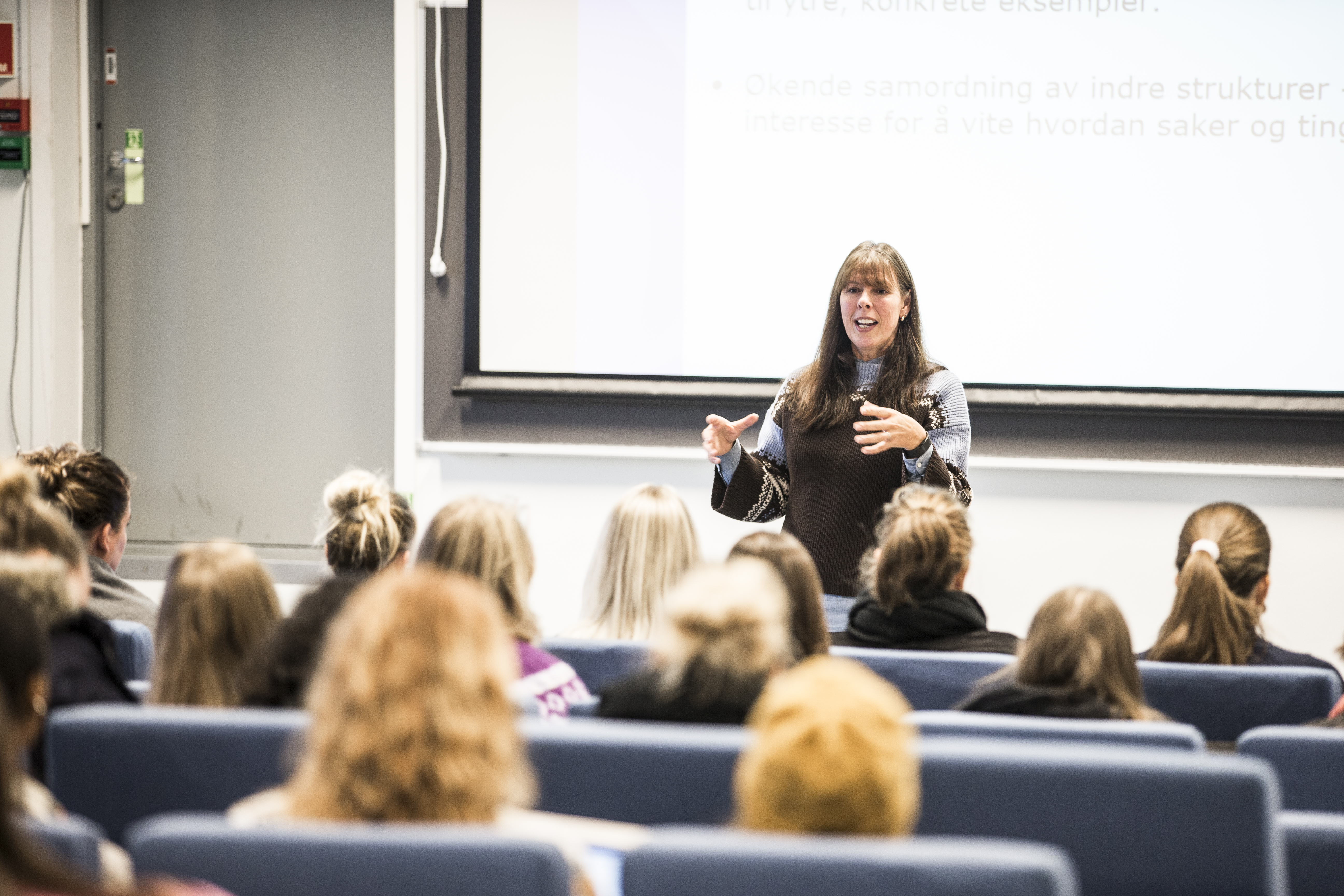 Kvinnelig lærer i klasserom underviser studenter