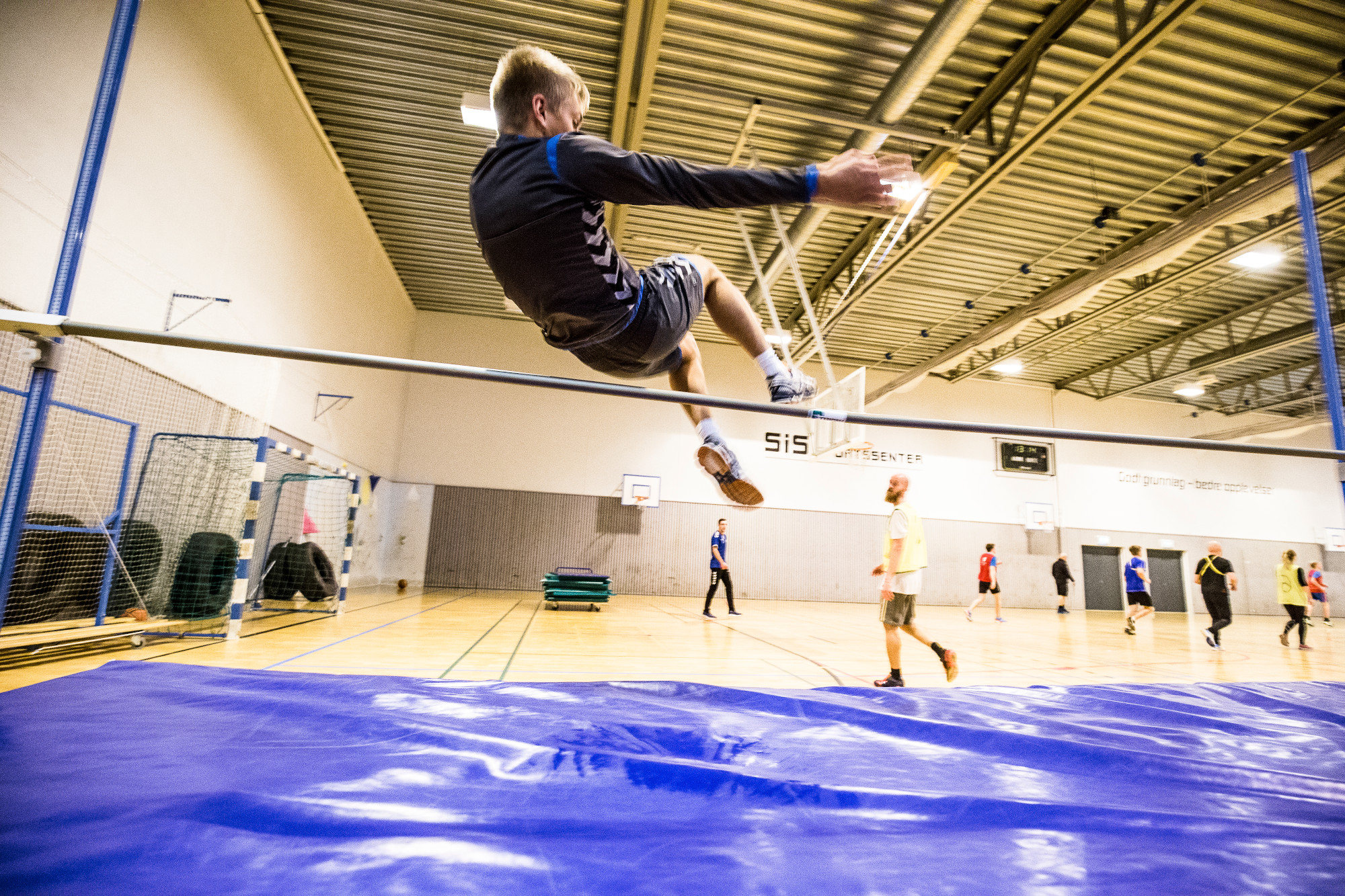 Mann gjør høydehopp i gymsal