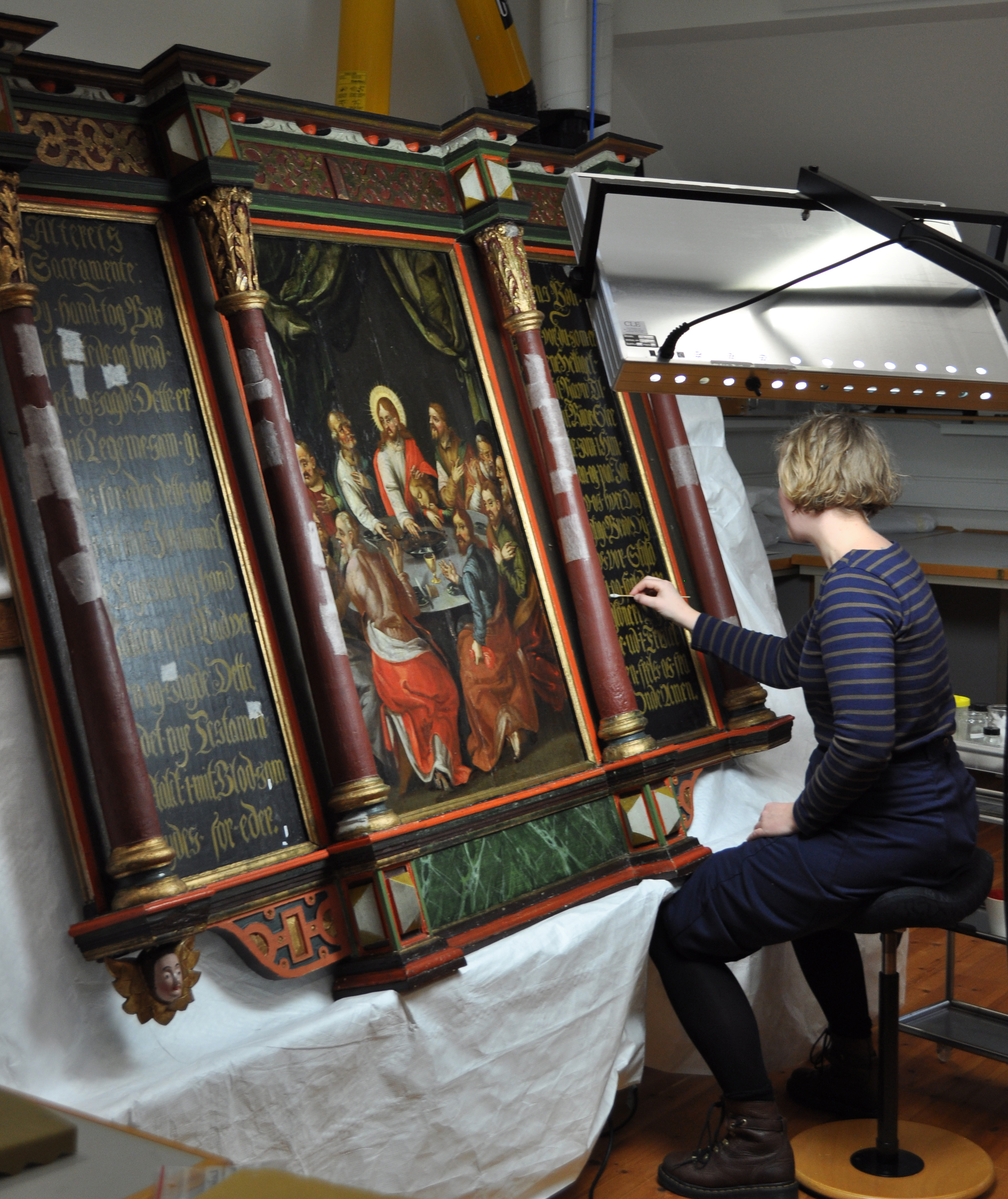 Malerikonserveringsstudent renser altertavlen fra Randaberg