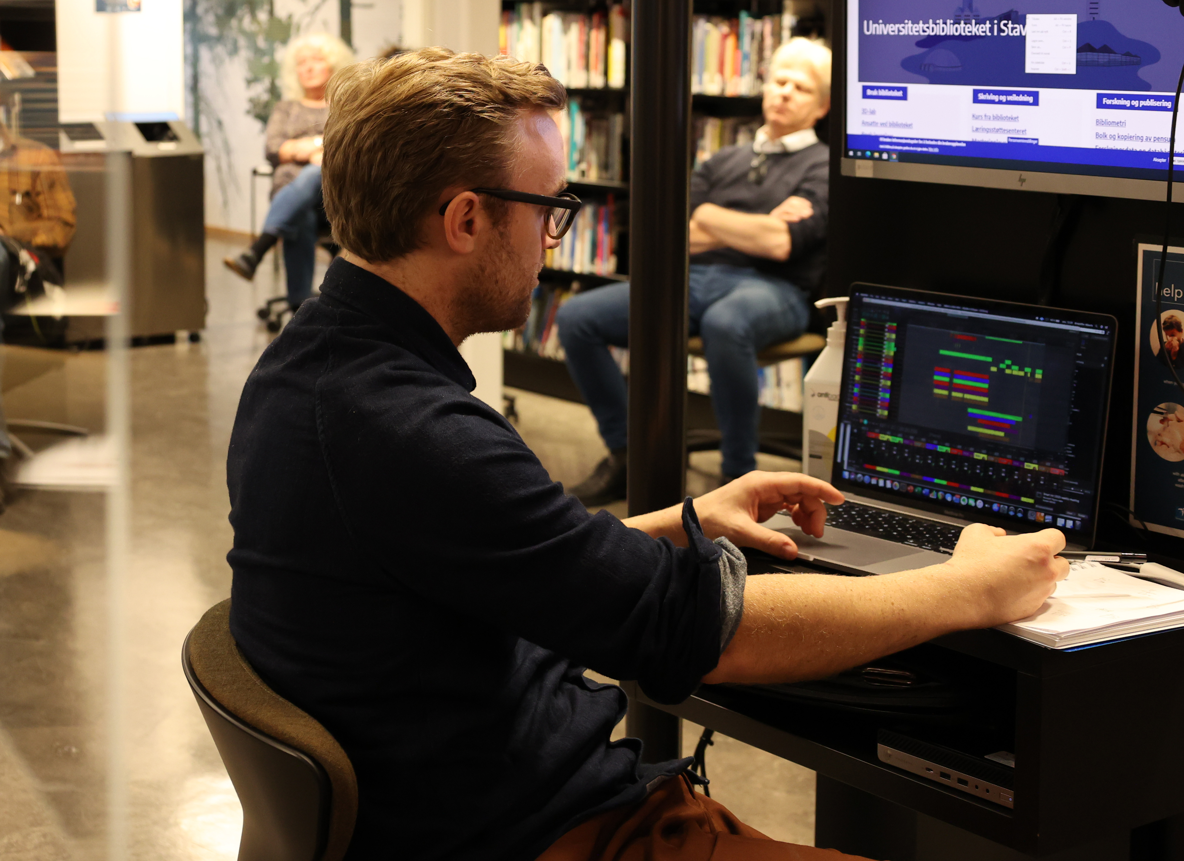 Kristoffer Berre Alberts sitter foran pc på et bibliotek