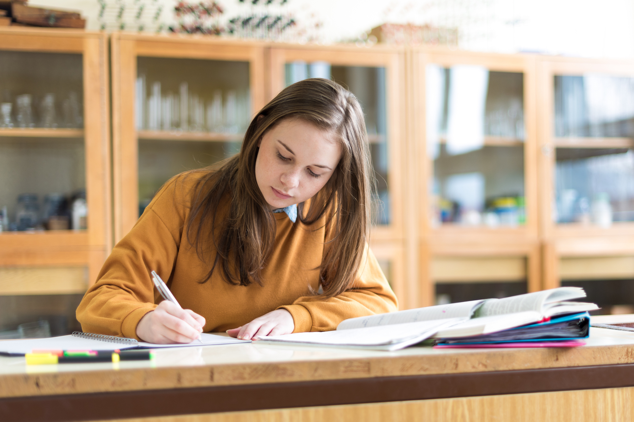 ungdomsskolejente skriver i klasserom