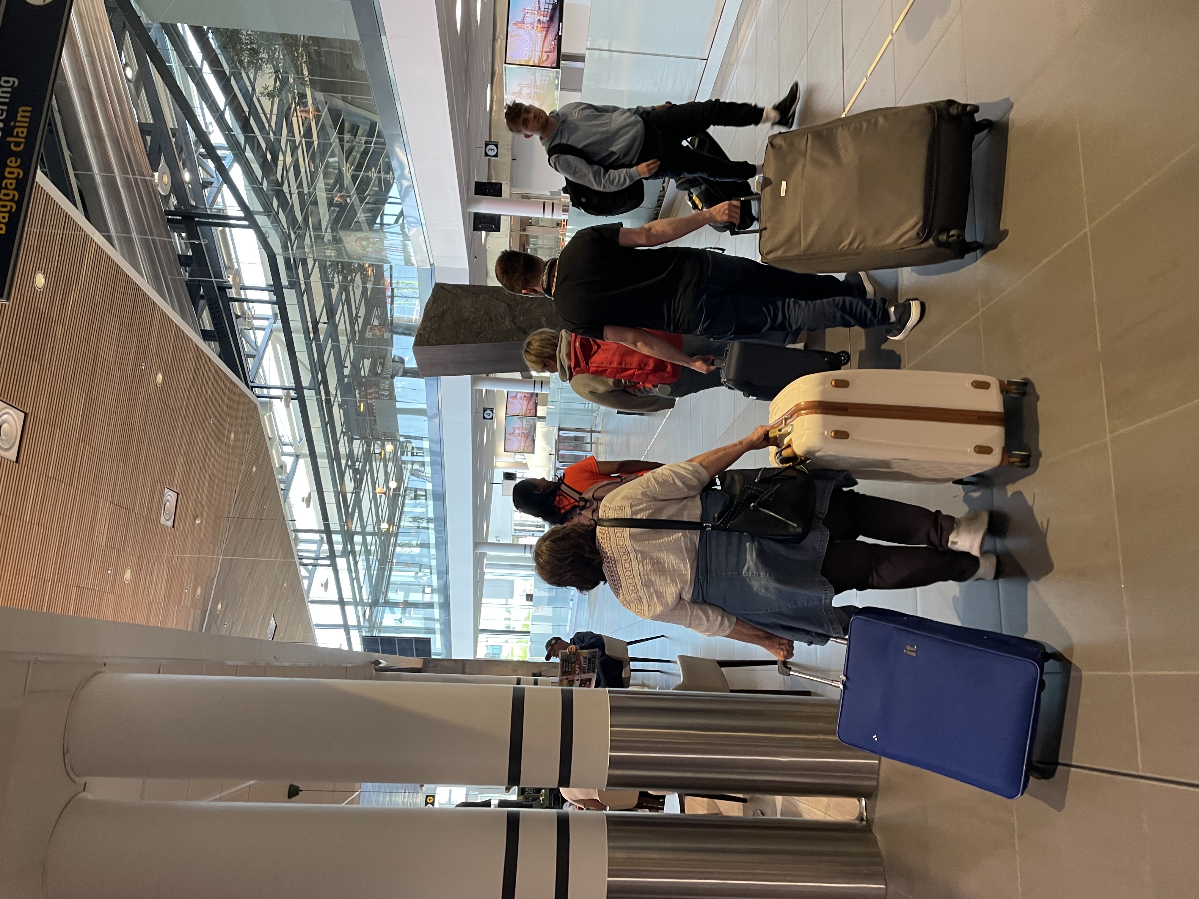 Studenter med ryggen til triller bagasjen sin på Stavanger Lufthavn