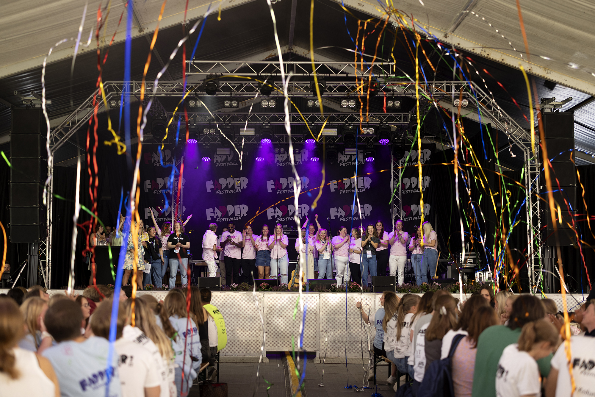 Scene fylt med studenter som skyter konfetti ut over publikum.