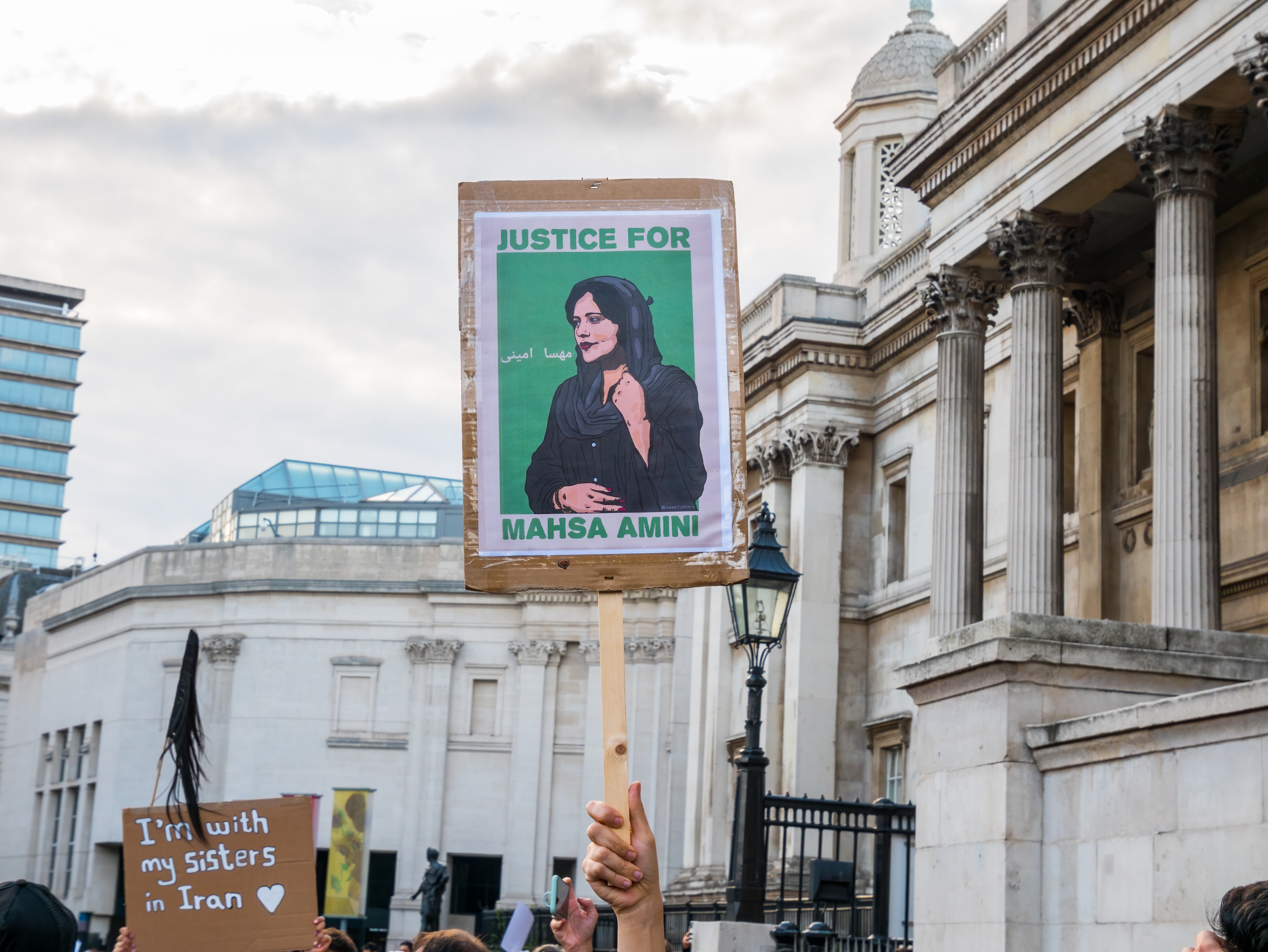 Protester i Iran, plakat med bilde av Mahsa Amini