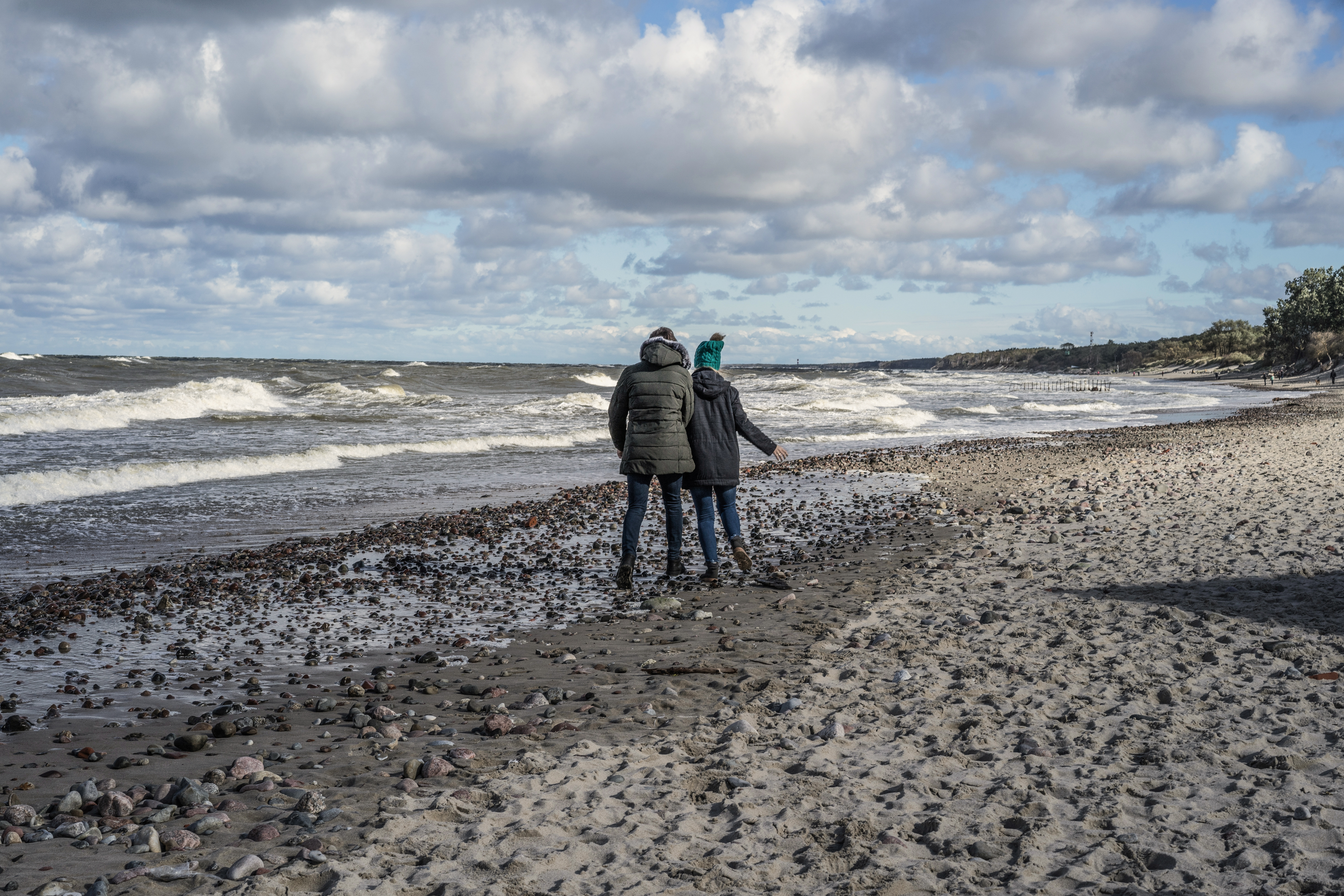 ungt par som står på en strand i kulden