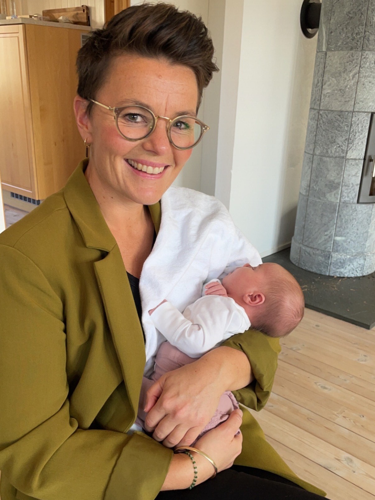 Portrett av helsesykepleier Kari Ugland, tidligere student ved UiS, som holder en baby