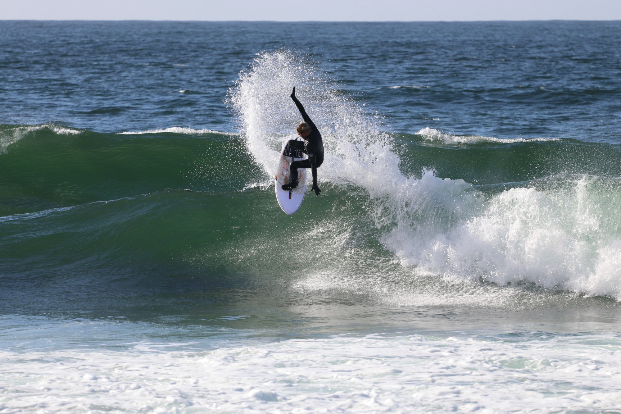 Bølgesurfer i brytende bølger i havet.
