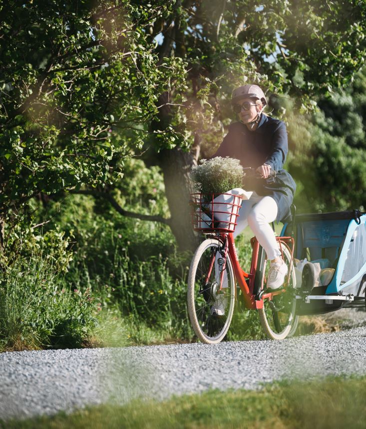 Kvinne på sykkel i grønne omgivelser