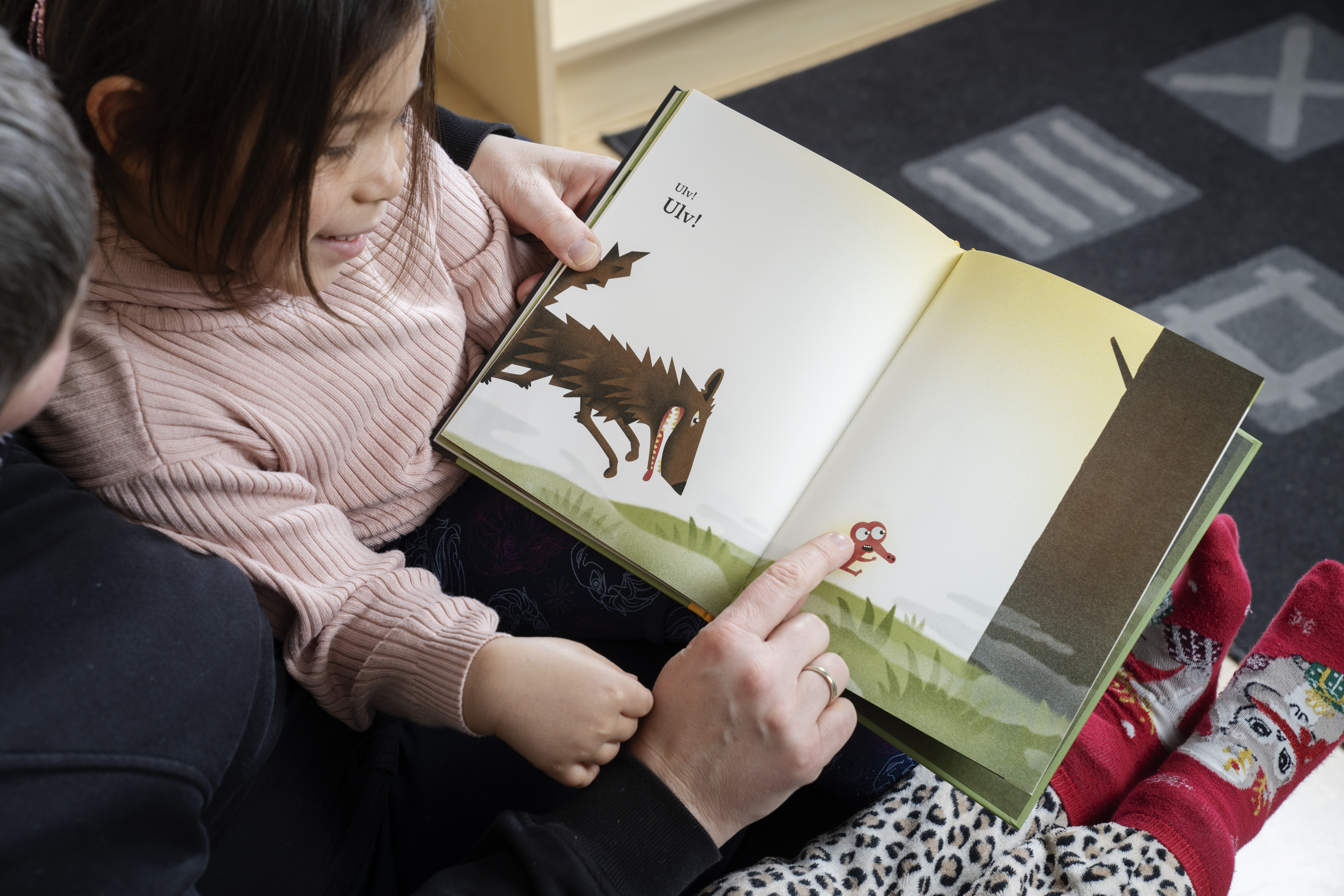 Barn i barnehage leser bok
