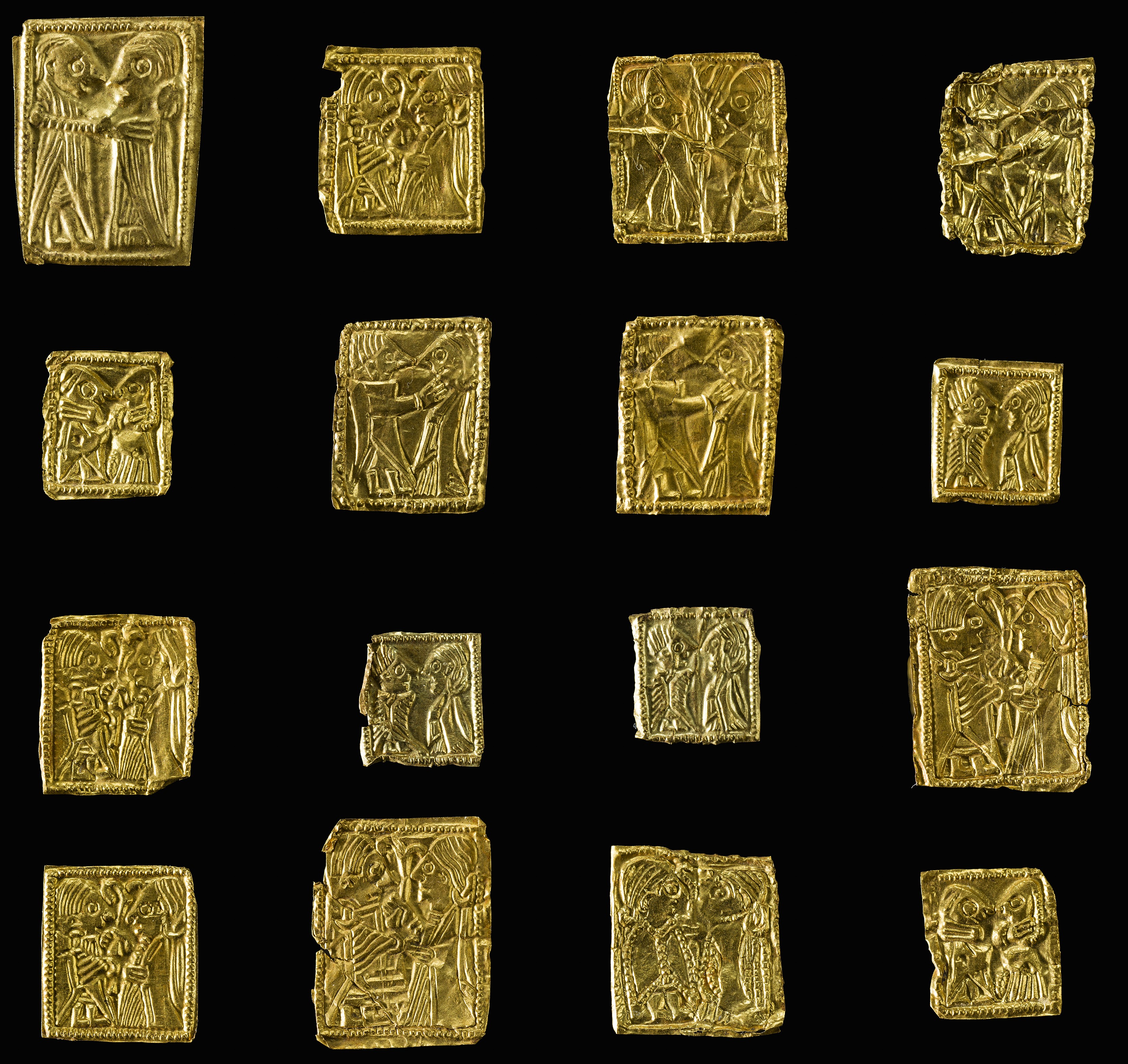Nærbilde av bittesmå flate gullplater med motiv på, knapt større enn en fingernegl.