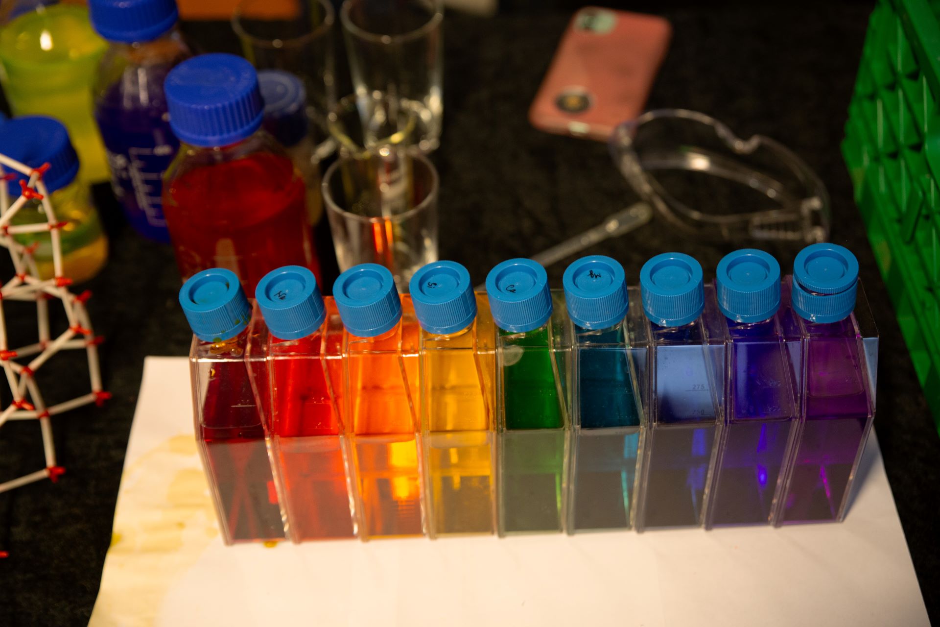 Regnbuens farger på små flasker på stand