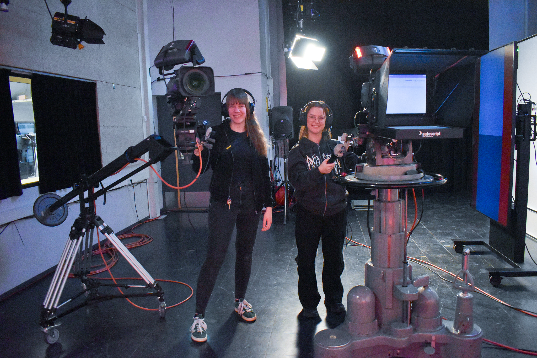 Studenter med store kameraer i TV-studio.