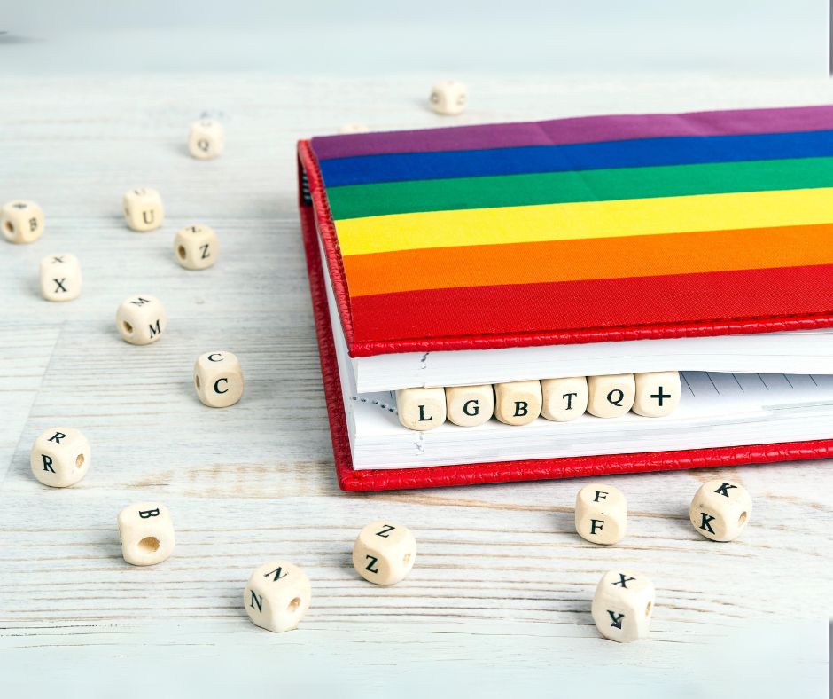 Bilde av en bok med Pride-flagg og terninger som har bokstavene LGBTQ+