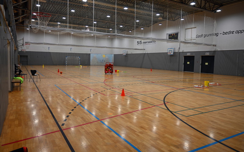 Fotografi av sportsbanen på SiS sportssenter, diverse sportsutstyr står på banen