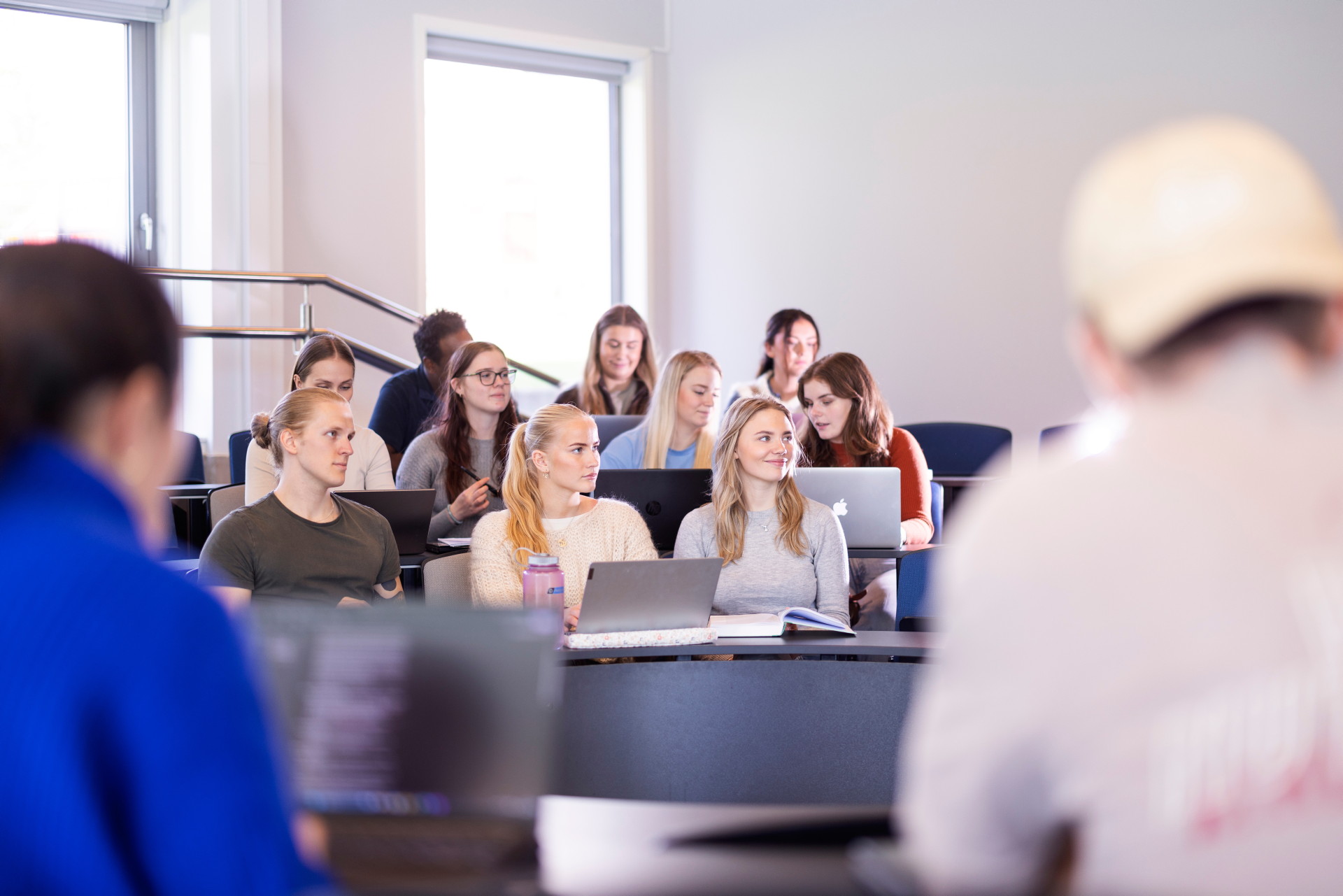 En liten gruppe studenter i forelesning med PCer