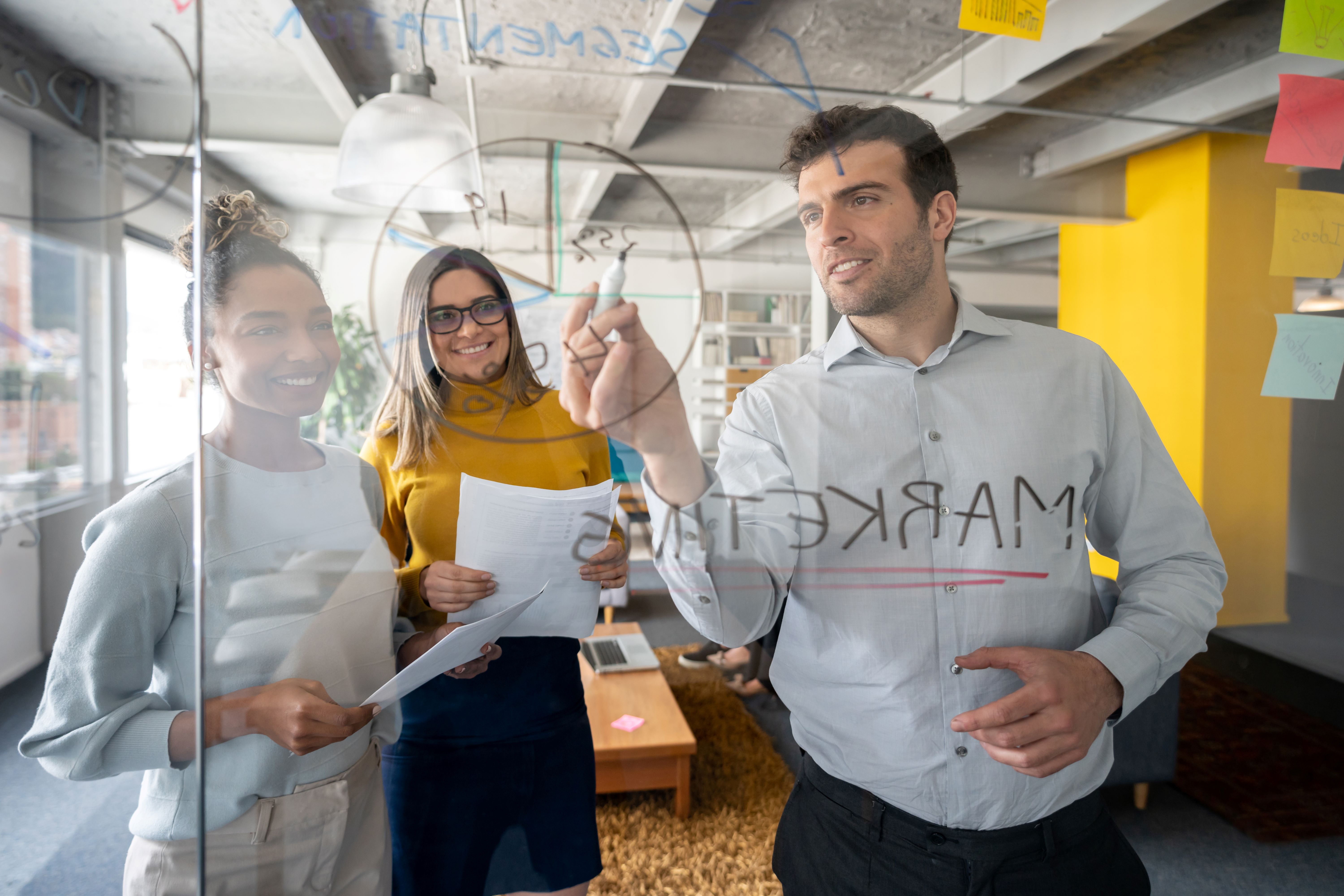 A group of people standing in front of a blackboard going trough ideas