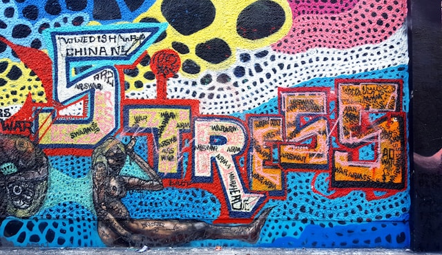 Graffiti med mange farger og ordet stress