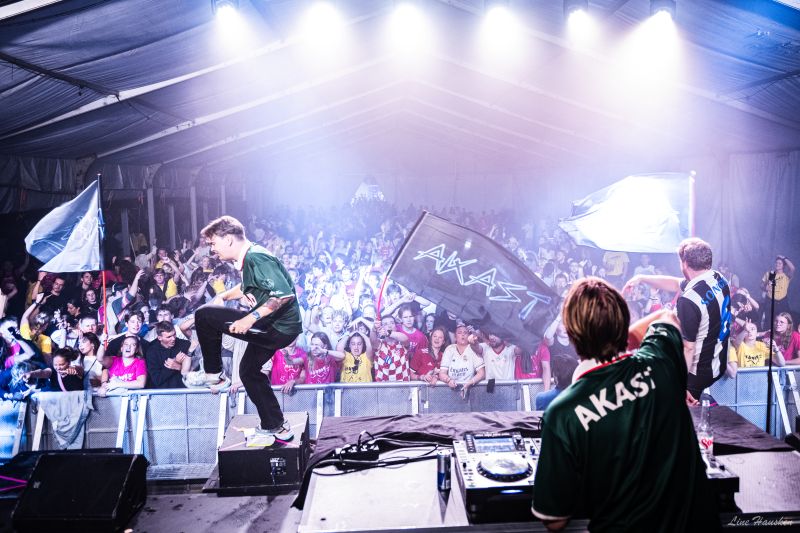To DJ-er står på en scene foran et stort publikum
