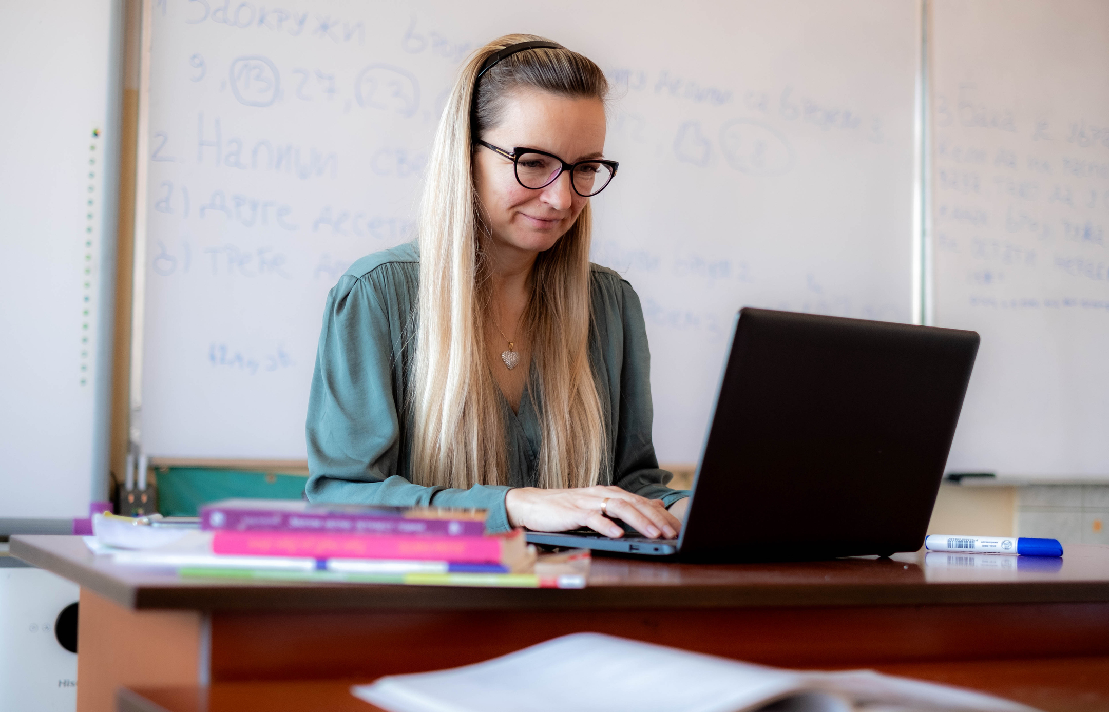 kvinne jobber på pc i klasserom
