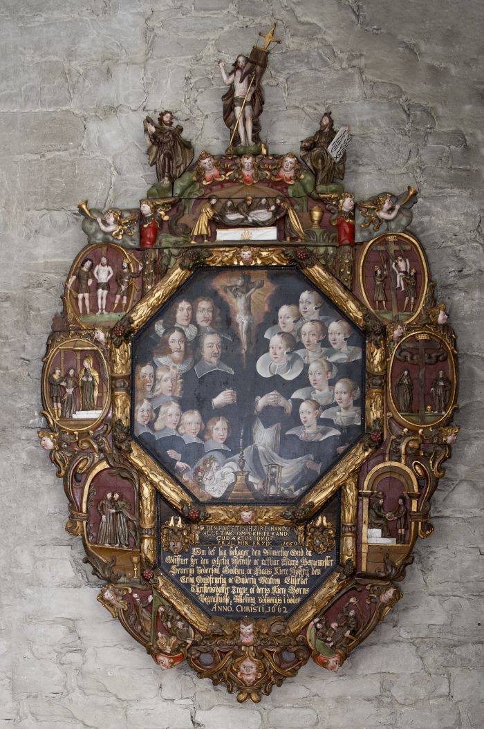 Portrett av familie inni massiv gullmalt og rikt utskåret treramme, med tekstfelt nederst i rammen