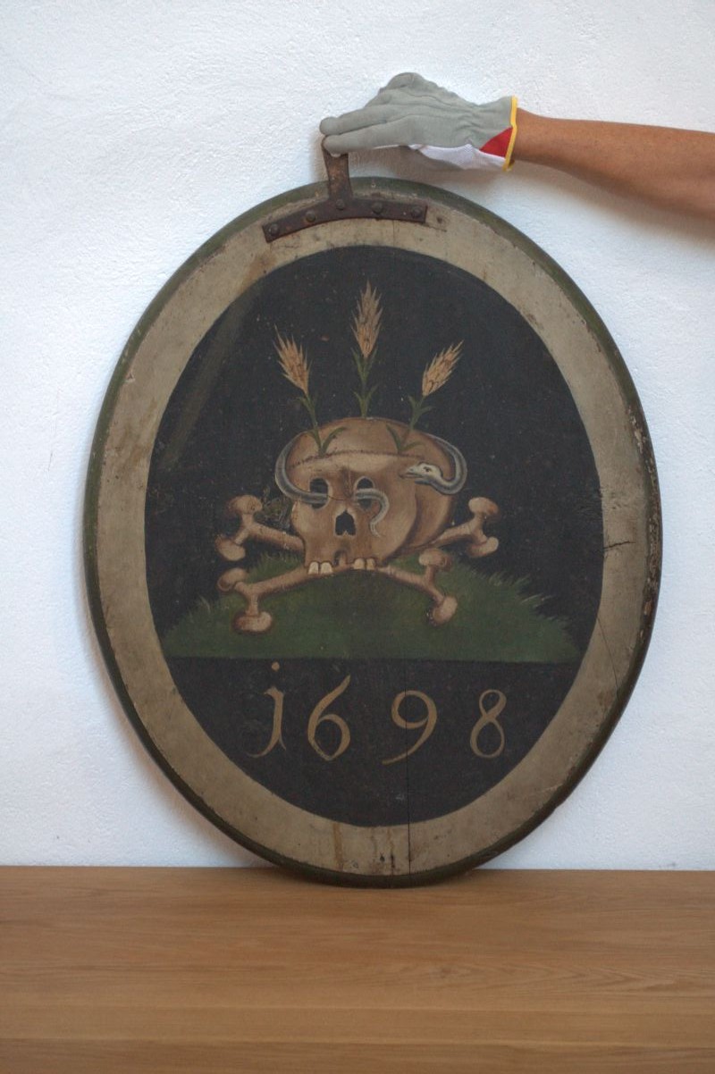 Oval minnetavle, bildeside. Brun med gullkant og tekst i gull.