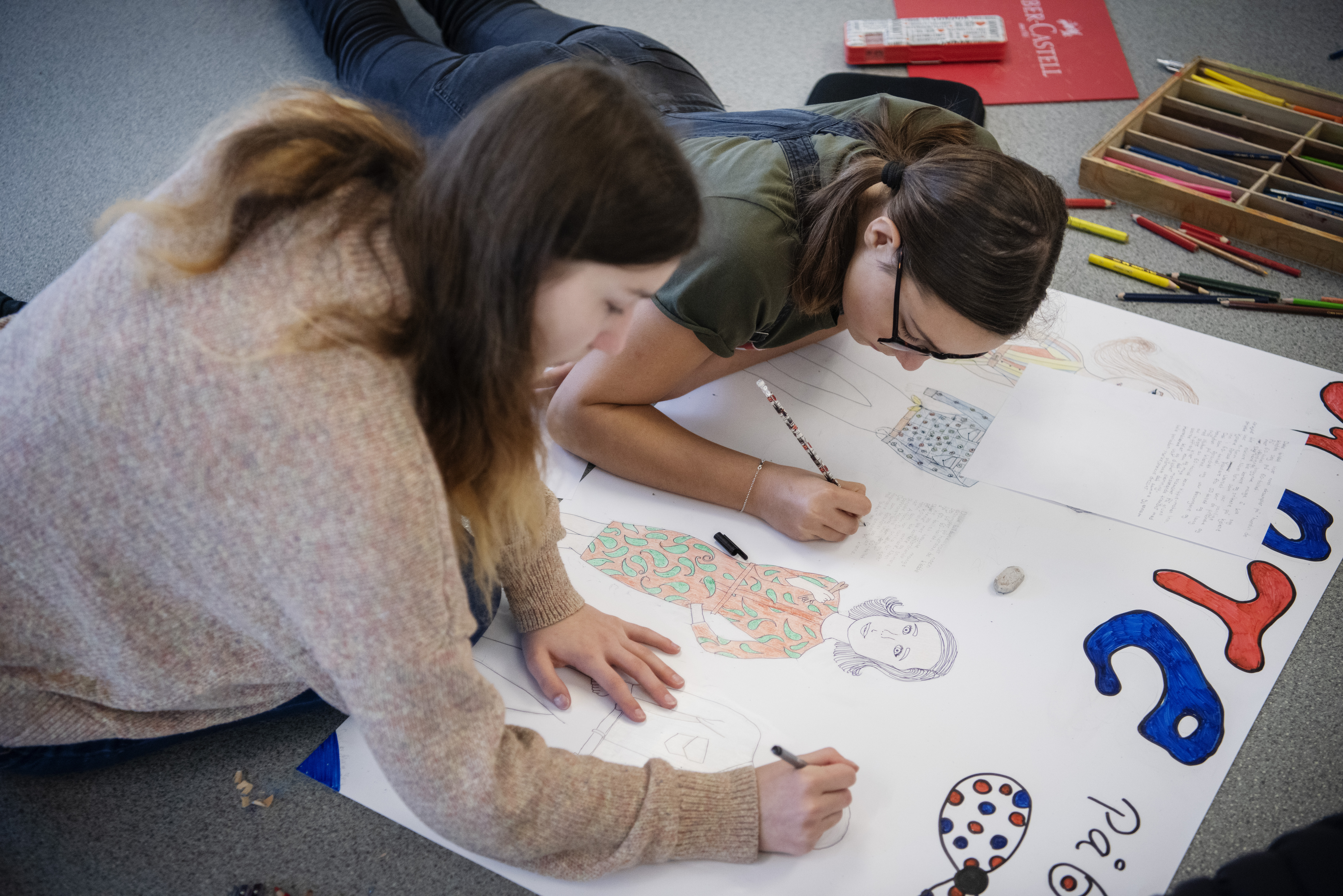 To jenter i ungdomsskolealder arbeider med en skoleoppgave.