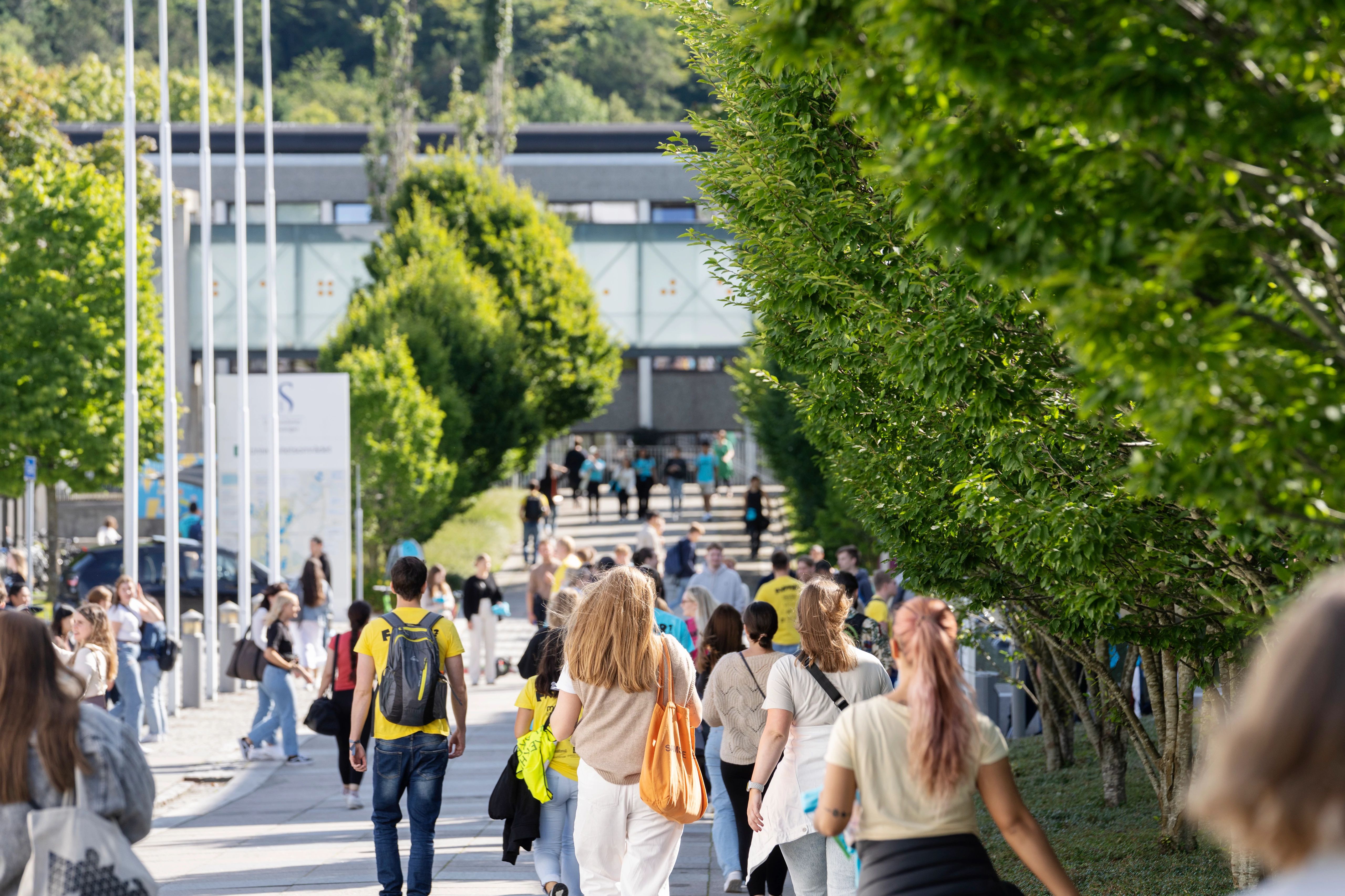 Mange studenter gående utendørs på campus Ullandhaug.