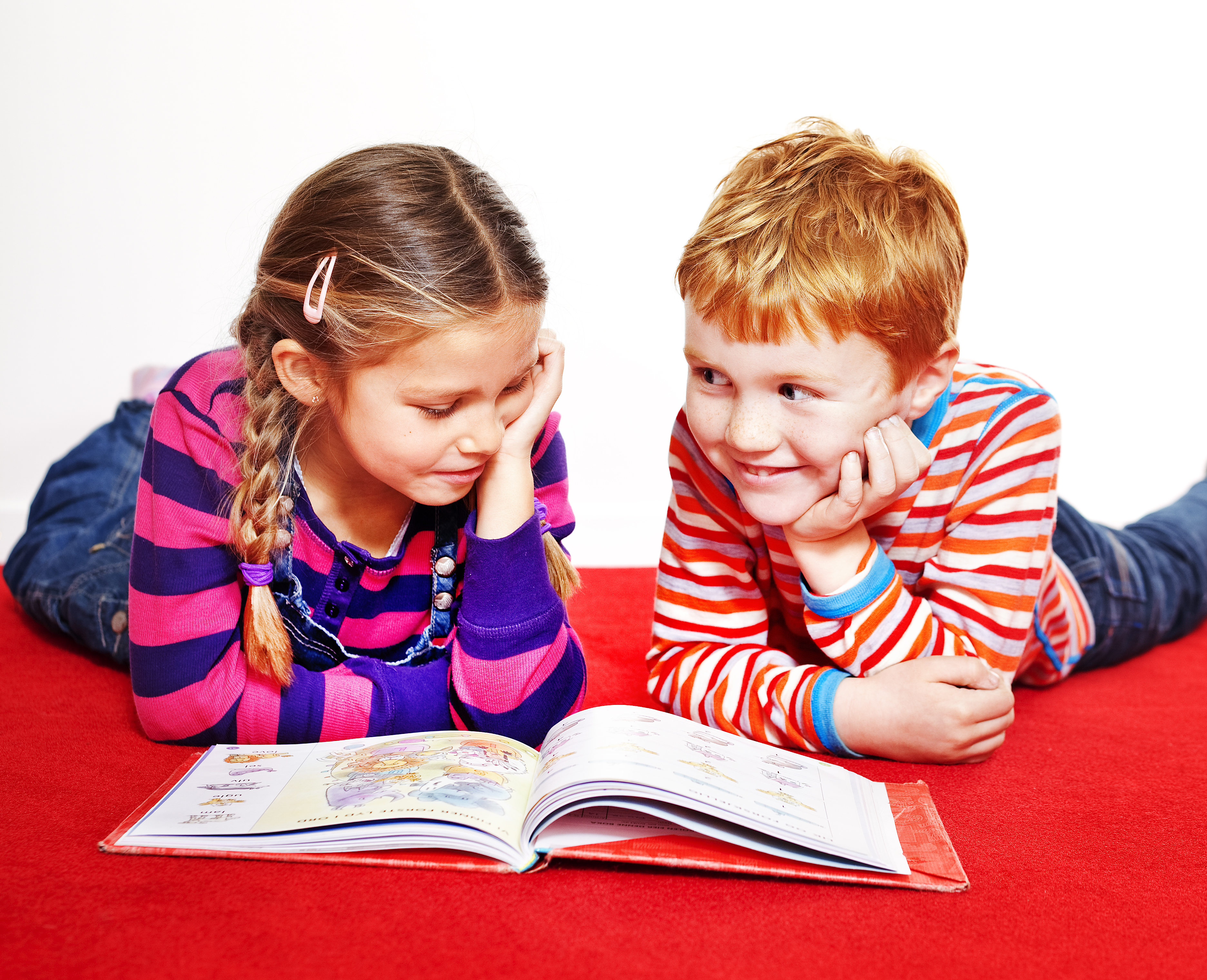 to barn leser bok på gulvet