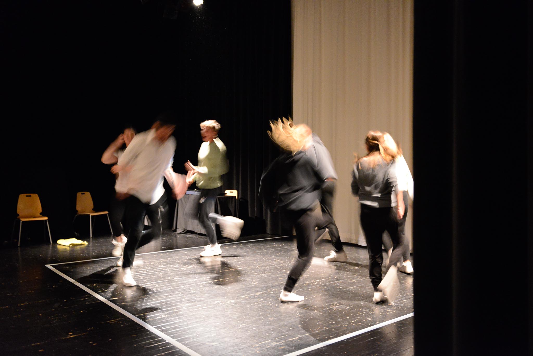 En gruppe personer danser på en scene.