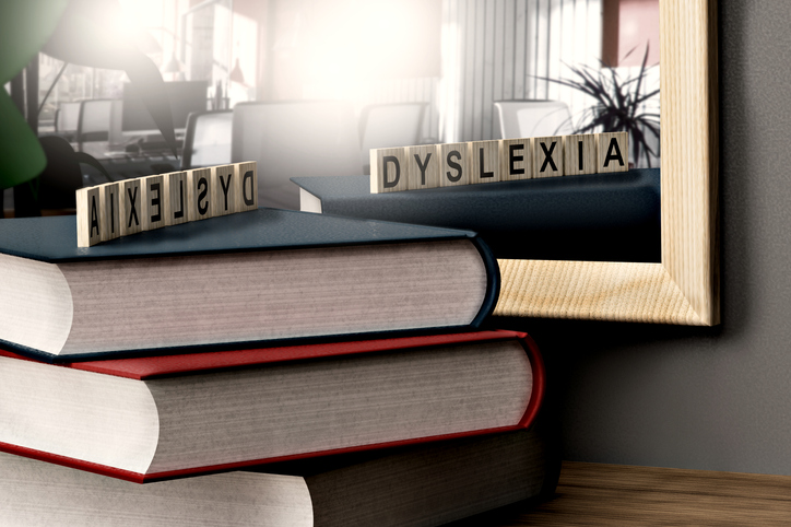 Bokstabel foran et speil, med bokstavbrikker som danner ordet dyslexia