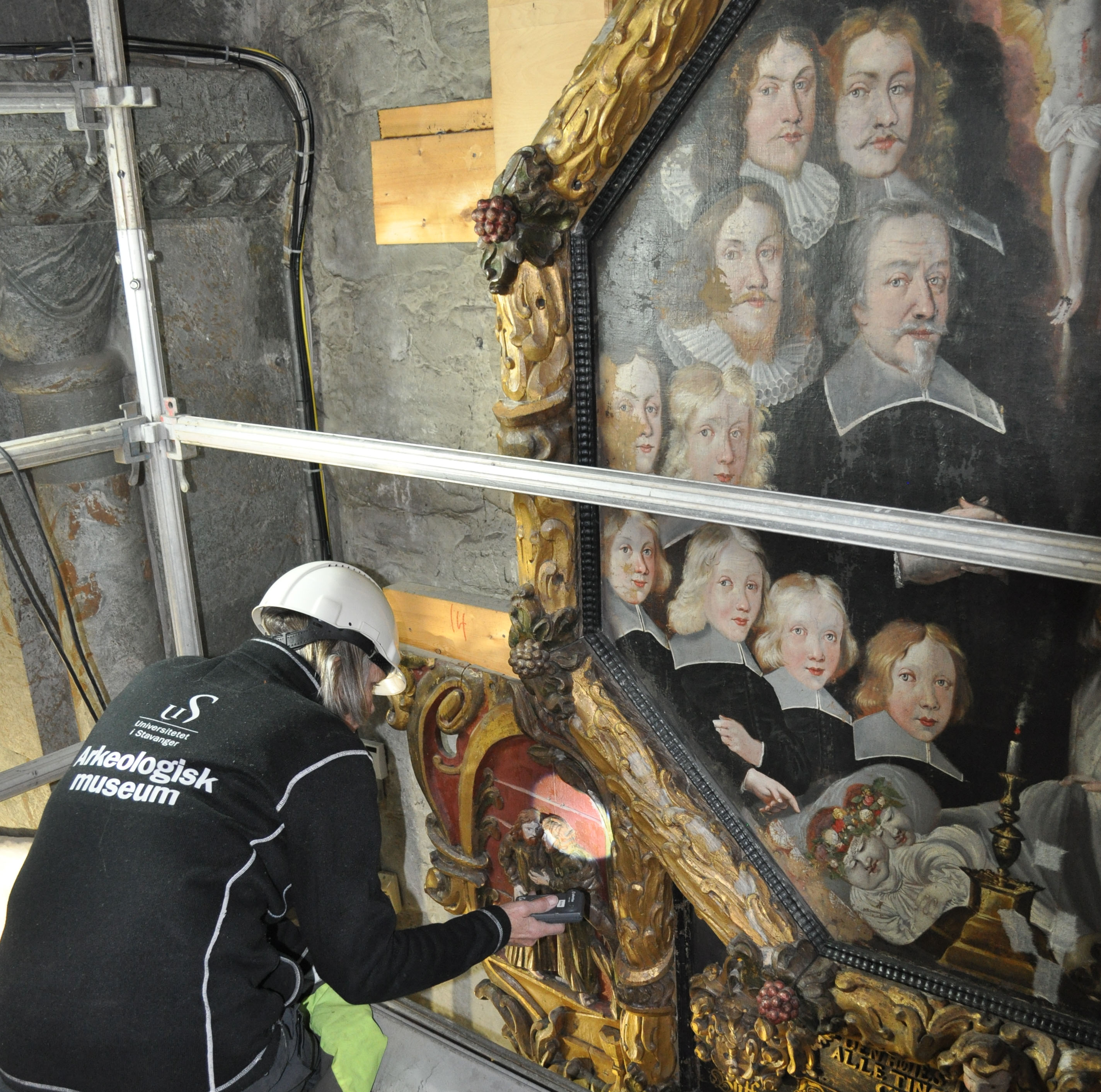 Malerikonservator undersøker Godtzenepitafiet før demontering