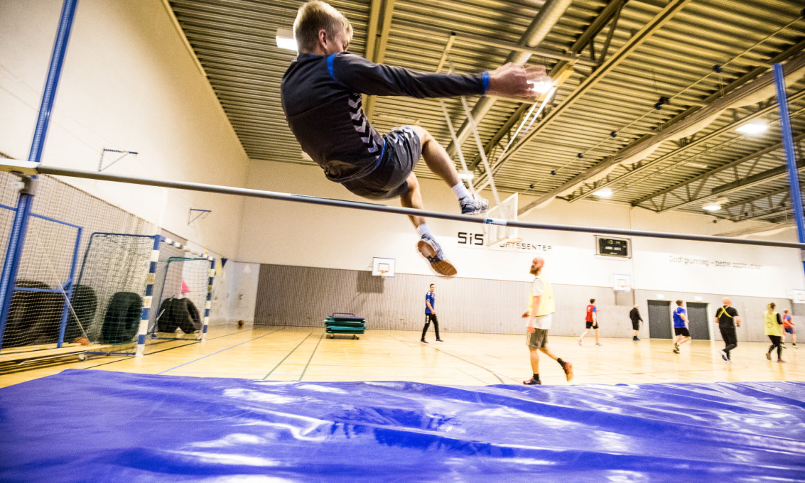 Mann gjør høydehopp i gymsal