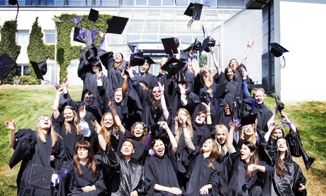 Alumner med hatter i luften