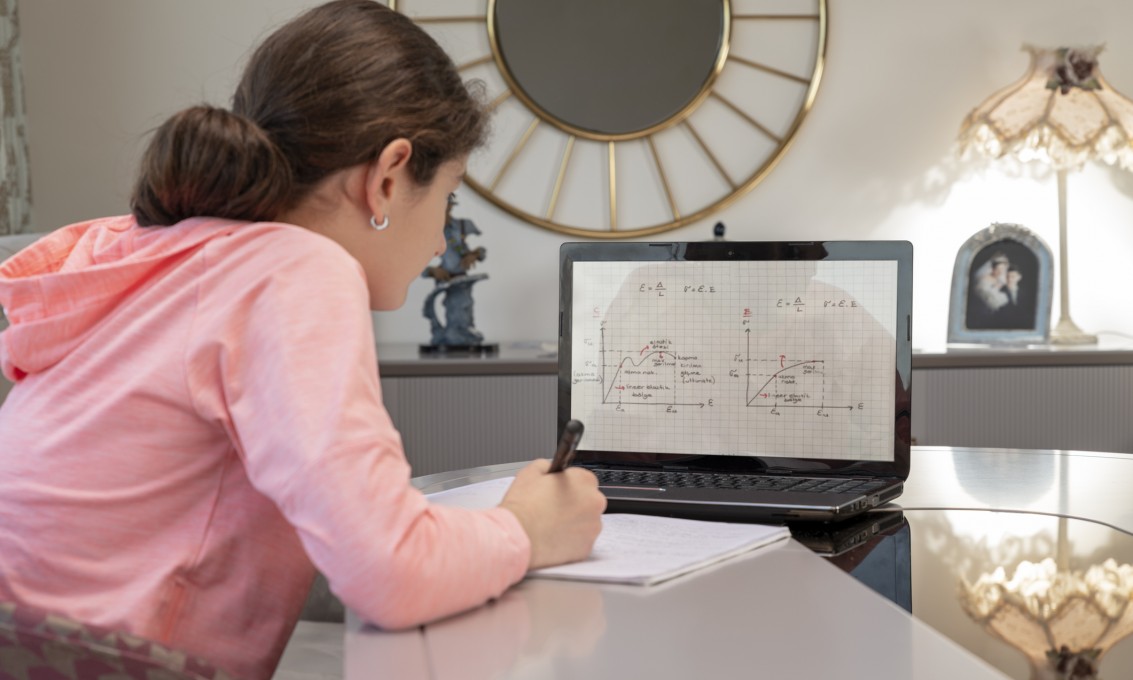 Jente får matematikkundervisning på hjemmeskole via datamaskin