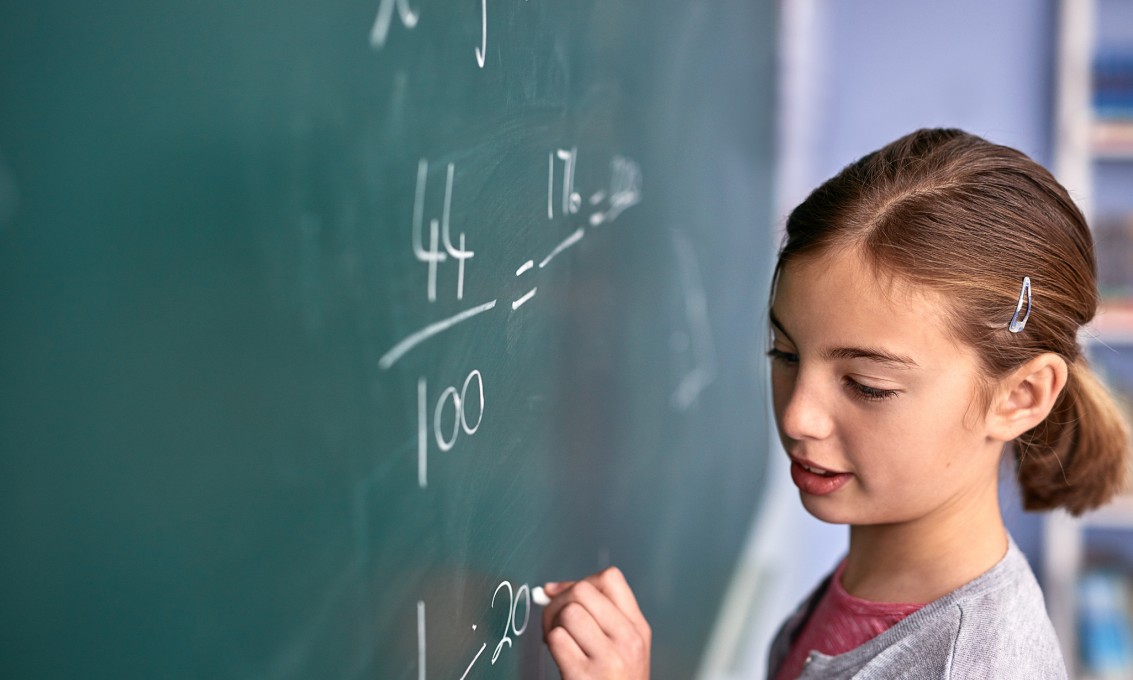 jente løser matematikkoppgave på tavle