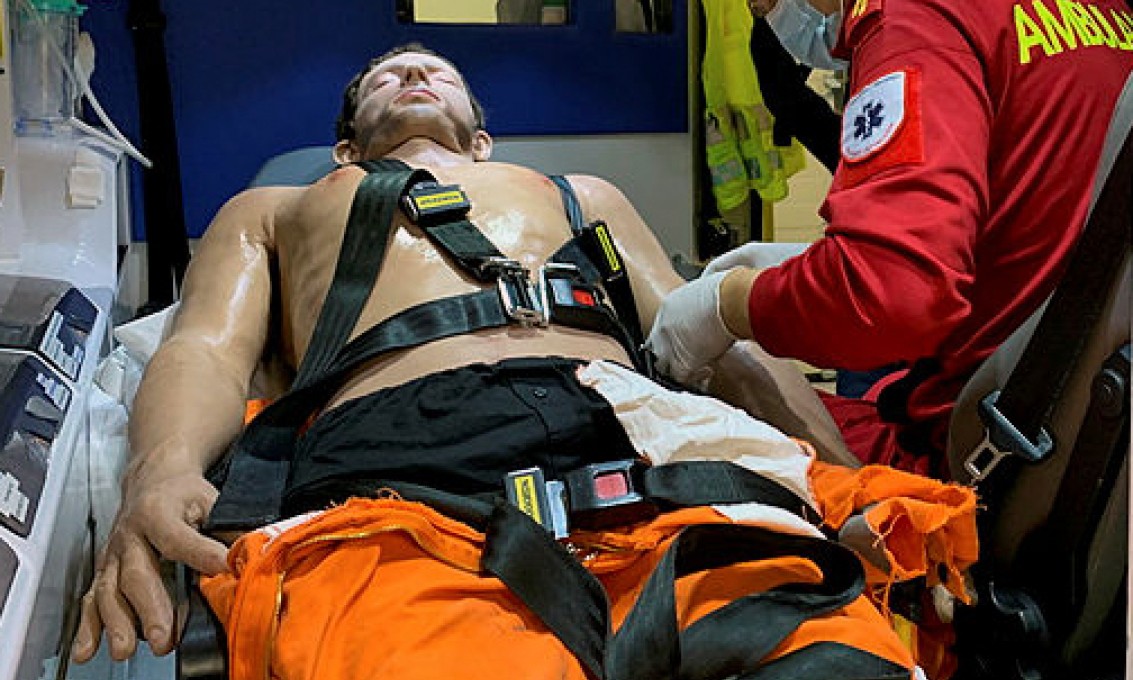 Paramedisinstudent Øyvind Grassdal simulerer behandling av pasient i en ambulanse.