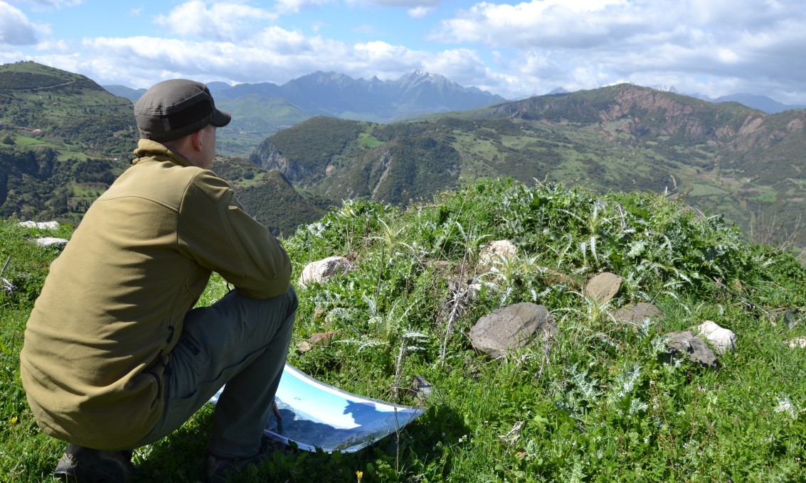 En mann ser mot et fjelllandskap. Foto