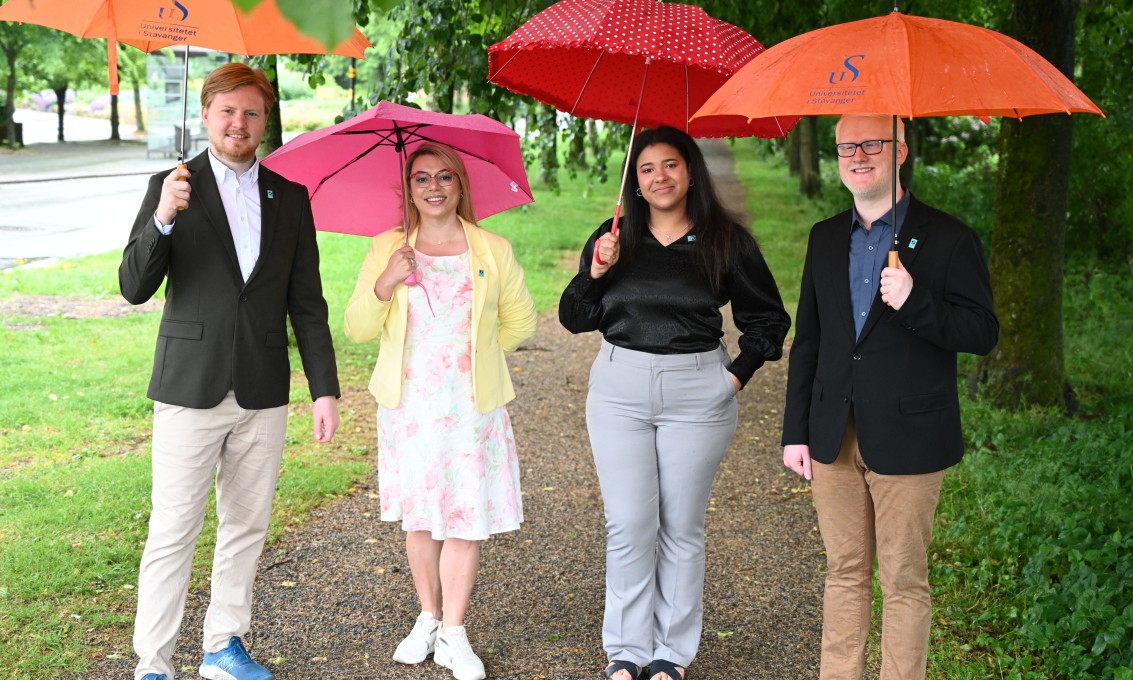 Fire personer under hver sin fargerike paraply.