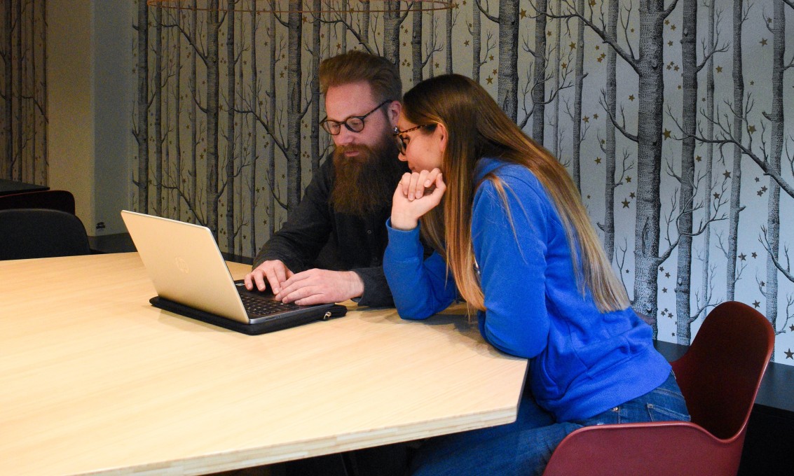 En student får veiledning i biblioteket