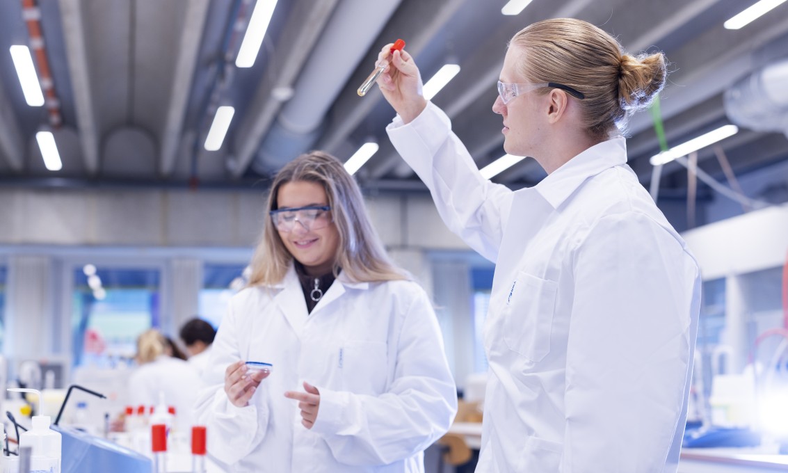To personer ikledd laboratoriefrakker jobber på et laboratorium. Foto.