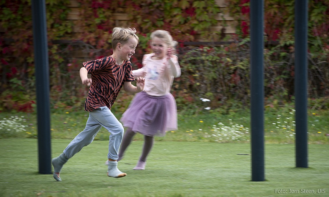 Jente og gutt løper i glad lek.