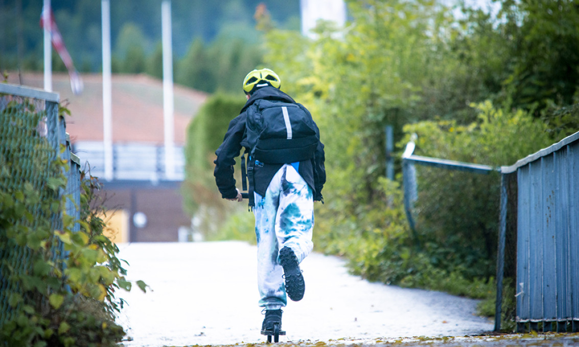 Gutt på skoleveien. Sett bakfra på sparkesykkel