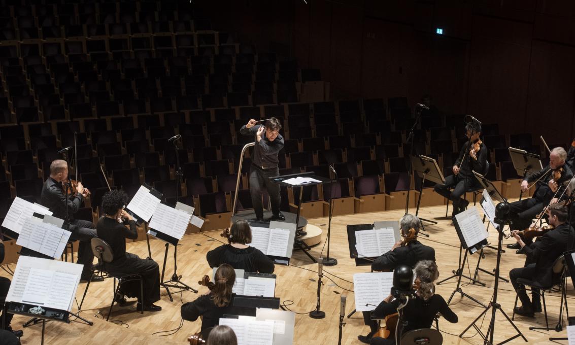 Orkester blir dirigert fra scene i Bjergsted