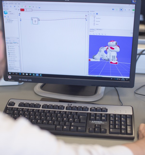 Kim Alstad foran pc skjerm humanoid robot koding datateknologi datavitenskap data student. Foto: Elisabeth Tønnessen