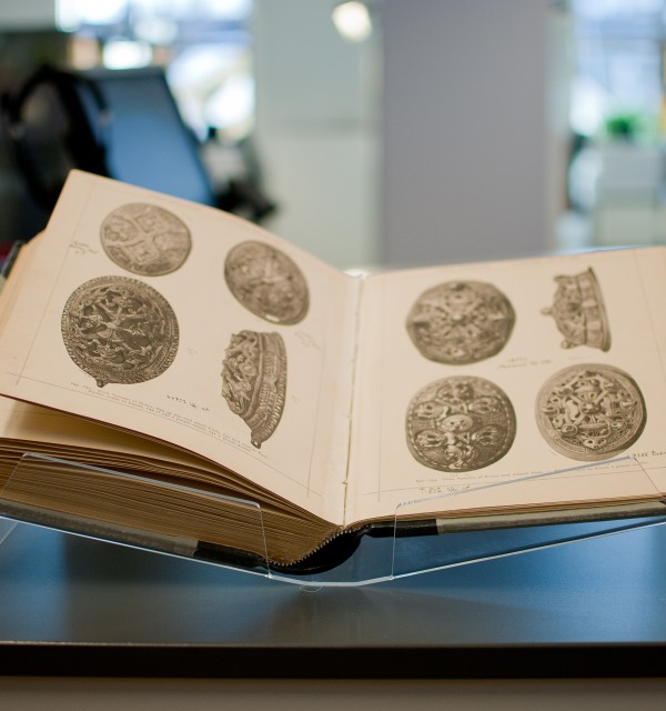 Åpen bok med bilder av arkeologiske gjenstander
