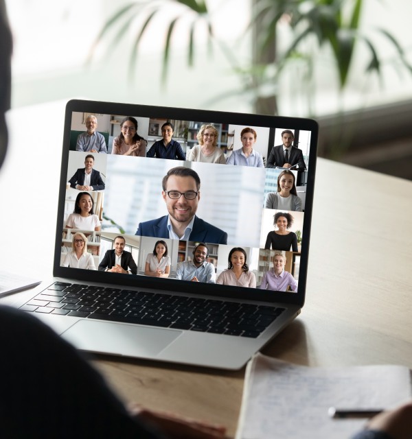 Kvinne med ryggen til i team-møte på laptop
