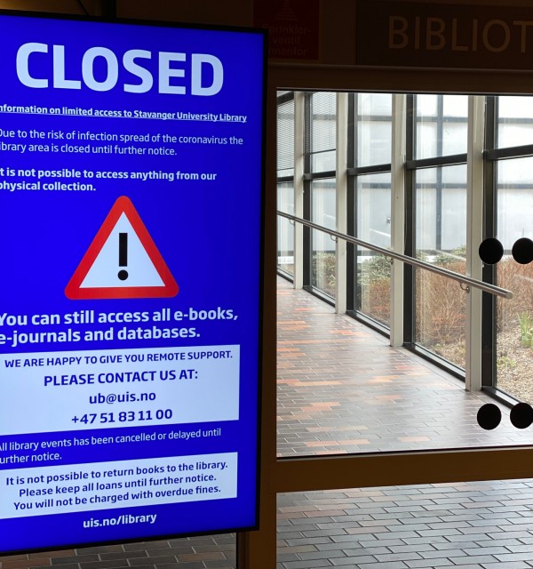 Skilt sier "CLOSED" foran inngang til universitetsbiblioteket på UiS