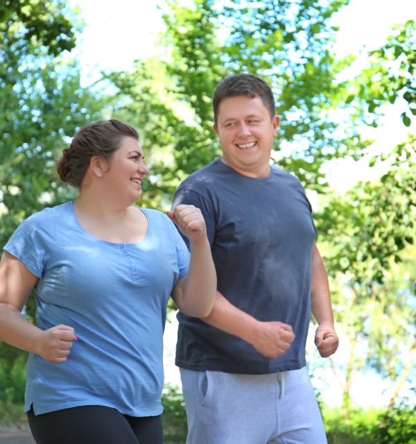 En overvektig mann og kvinne går tur i parken
