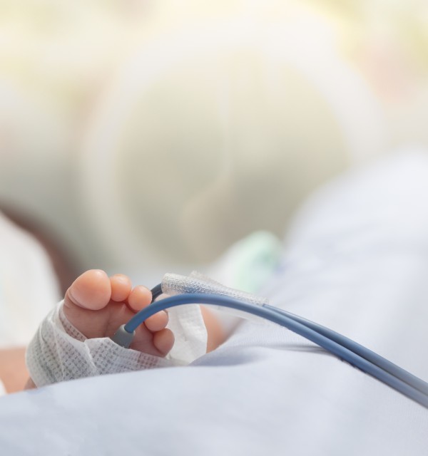 Nærbilde av føttene til et spedbarn eller nyfødt baby med pulsoksymeter