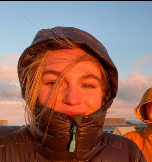 Student Camilla Ringhagen er ute en vinterdag i solnedgang. Det er kaldt, det blåser og hun har trukket den svarte boblejakken godt opp i ansiktet og trukket hetta over hodet. 